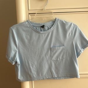 Cropped light blue shirt with a pocket in the front
